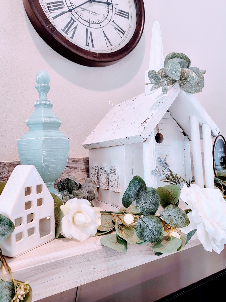 Vintage style white church birdhouse repainted with faux floral and displayed as home decor.
acrossthelake.blog