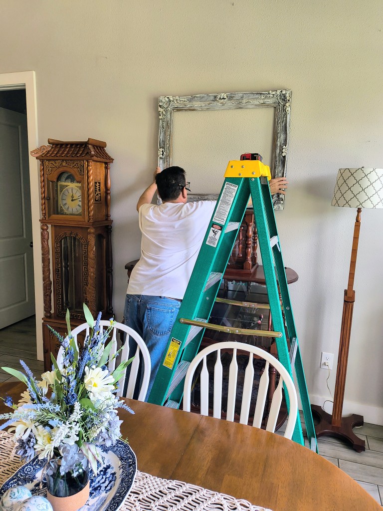 Hanging up a large picture frame.
acrossthelake.blog