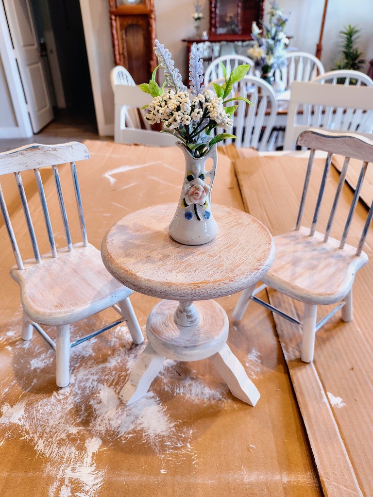 Miniature wooden table and chair set finished paint project in whitewash and blue with miniature vase and flowers.
acrossthelake.blog