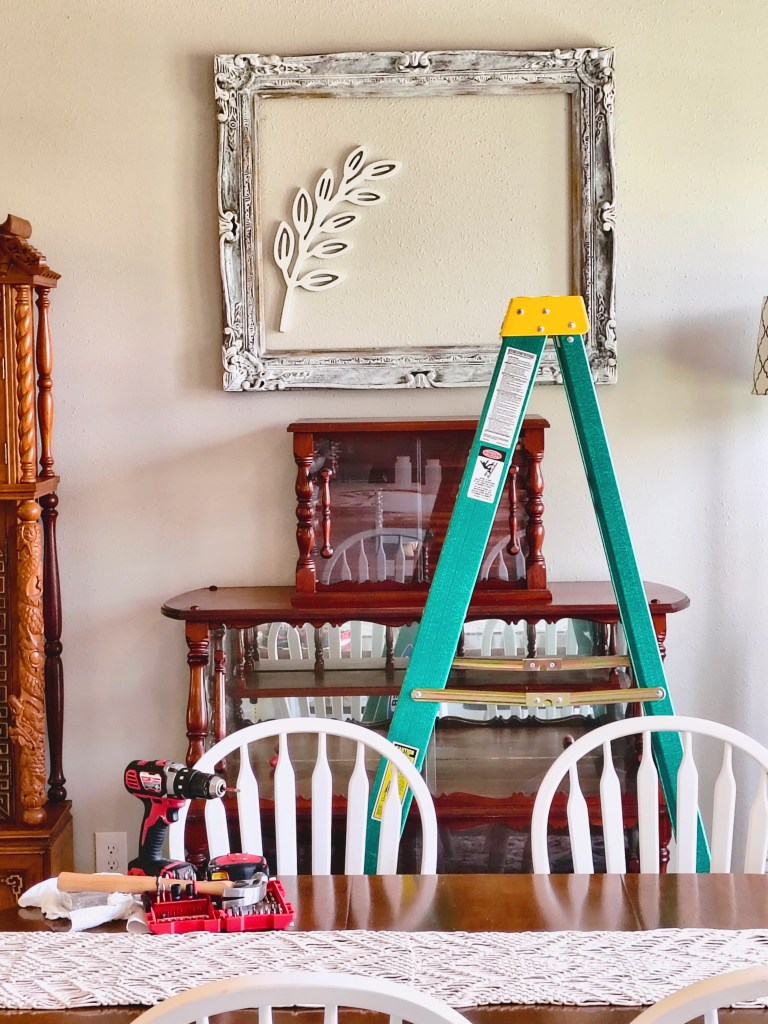 White washed wooden frame with wooden leaf cutout inside.
acrossthelake.blog