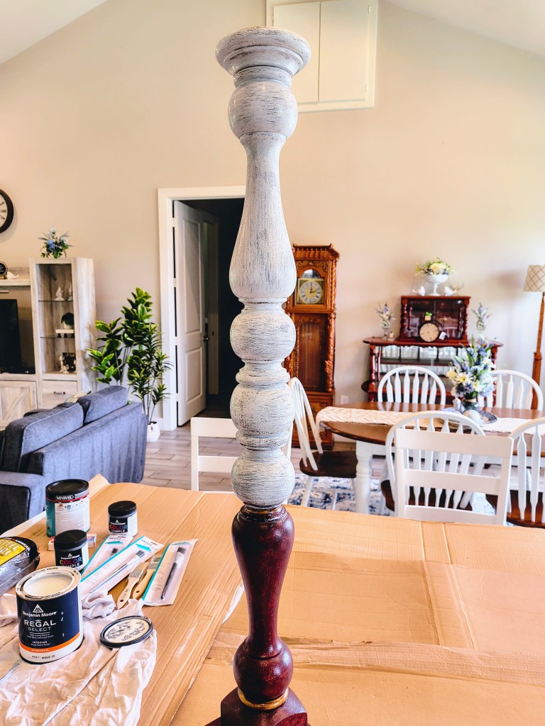 Wooden candlestick holder being painted.  First coat of white paint.
acrossthelake.blog