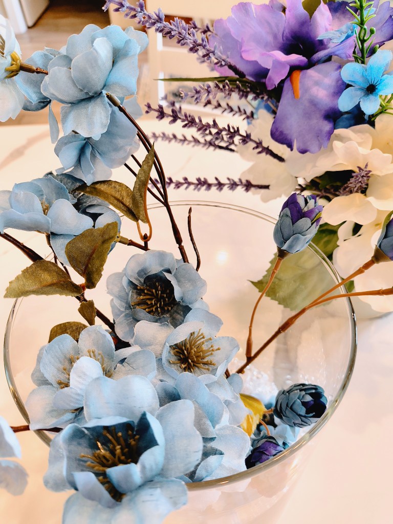 Simple blue faux floral arrangement in a glass jar.
acrossthelake.blog