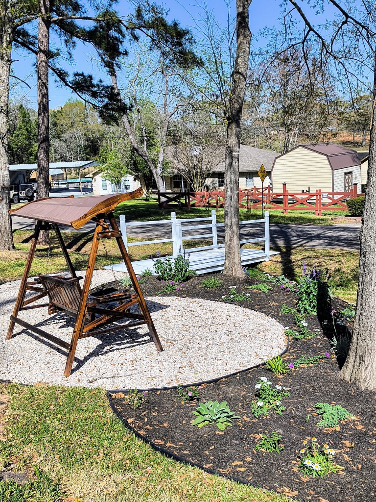 Covered swing in garden area. acrossthelake.blog