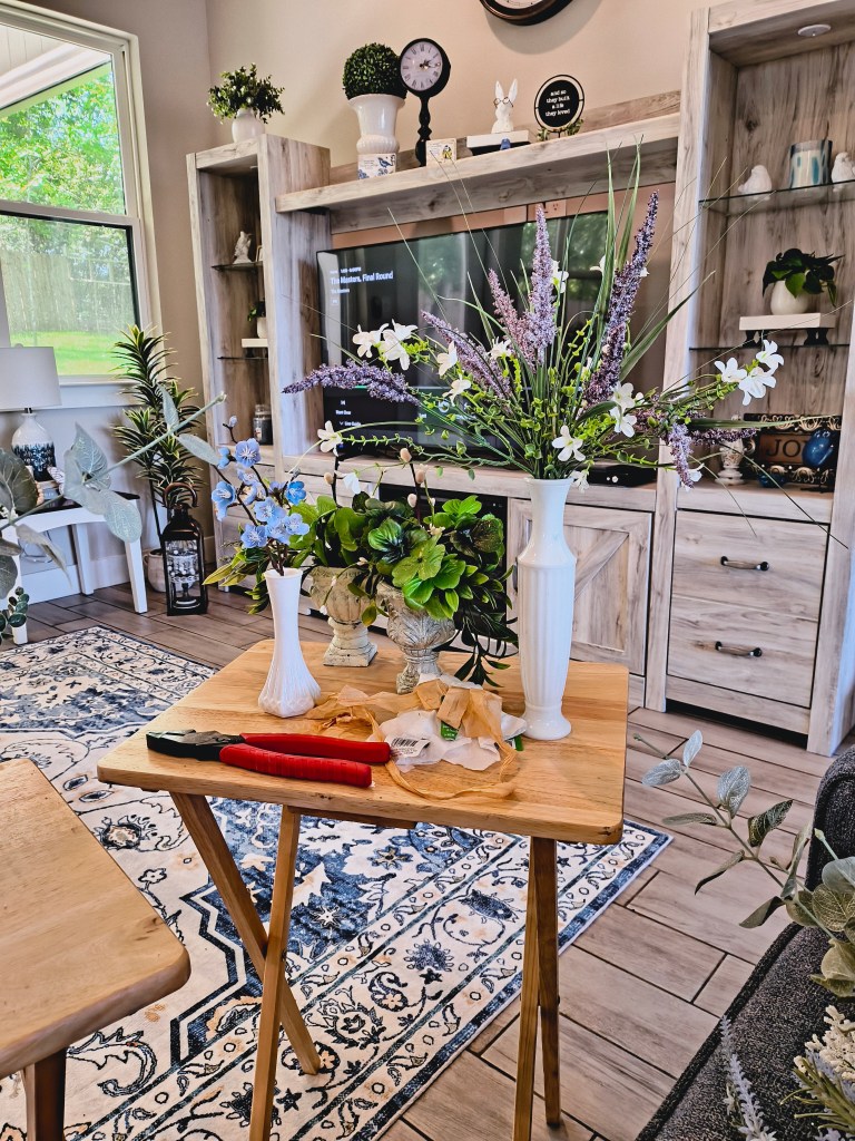 Purple and white faux floral arrangement in white milk glass vase.
acrossthelake.blog