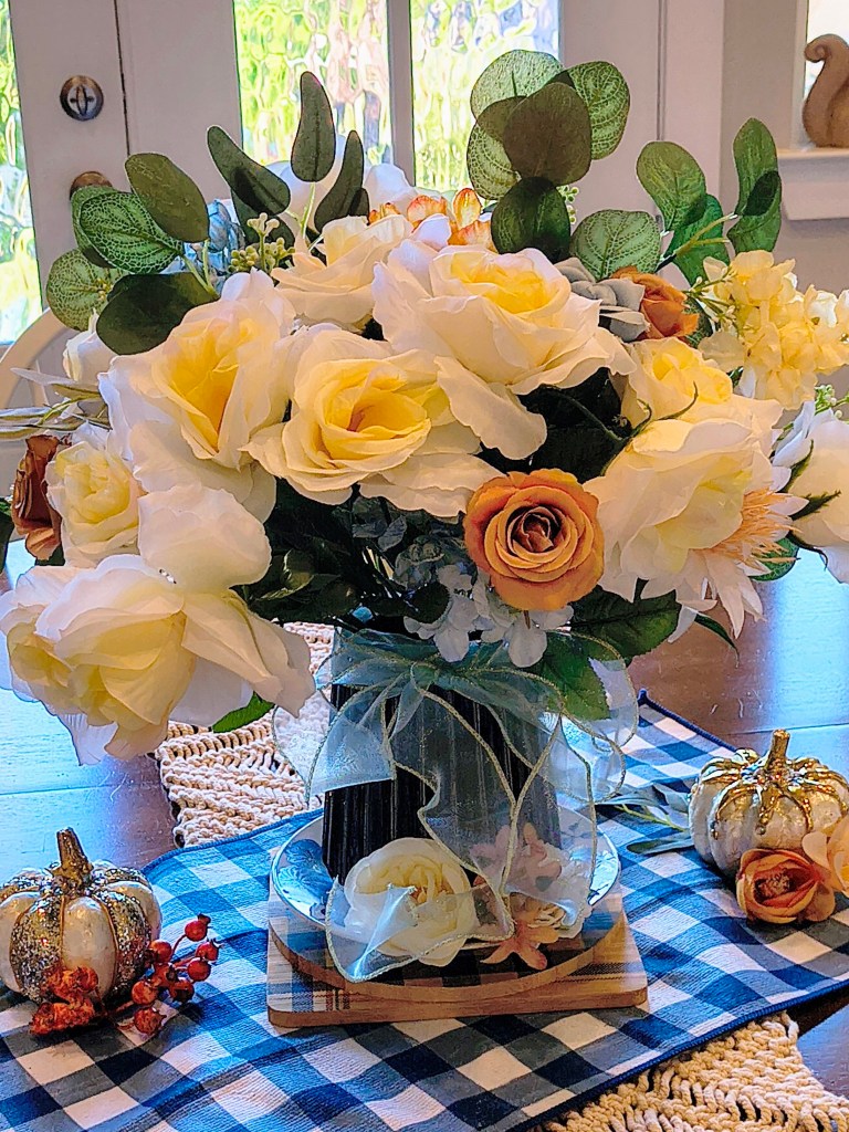 Fall faux floral dining room table arrangement in creme, blue and light rust.
acrossthelake.blog